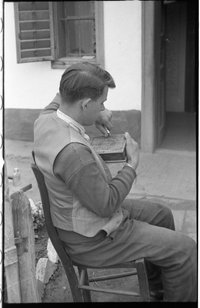 Fiatal férfi egy fadobozt faragással díszít